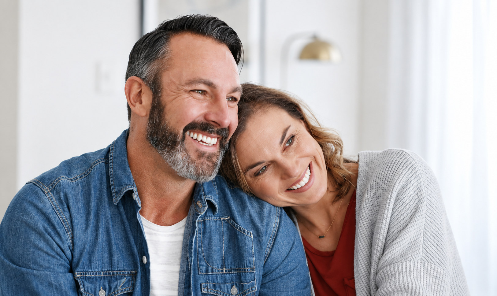 A couple in their forties laughing together at home